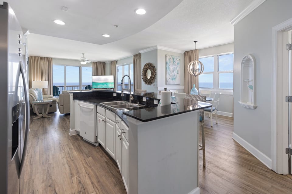 Prepare your favorite meals in this bright, open kitchen with sleek countertops and stainless steel appliances, all while enjoying stunning ocean views through floor-to-ceiling windows.