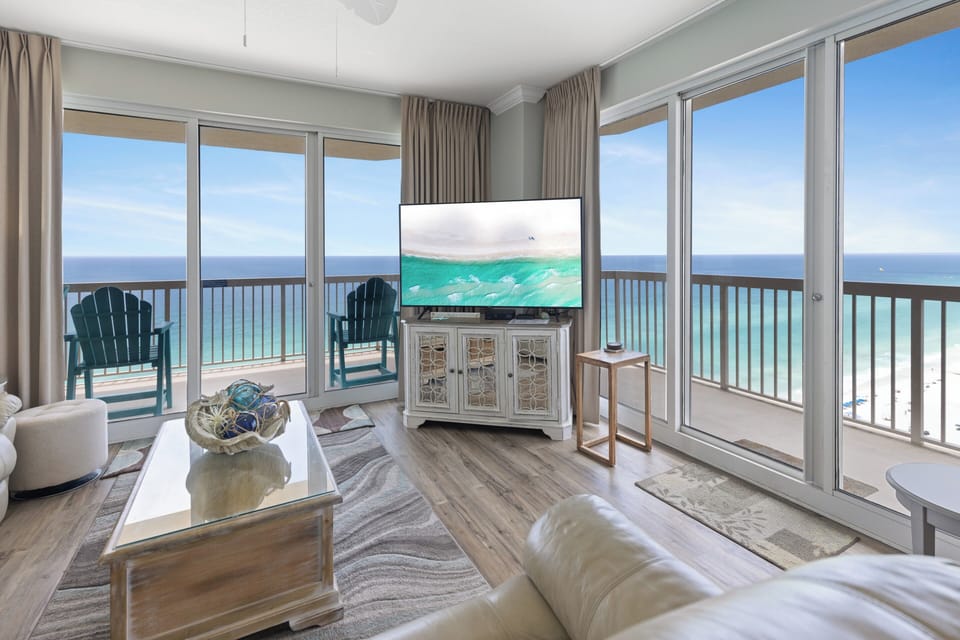 Relax in your coastal living space with sweeping ocean vistas beyond your private balcony. Glass doors frame turquoise waters and endless blue horizons, creating a serene retreat where the beach meets your comfort.