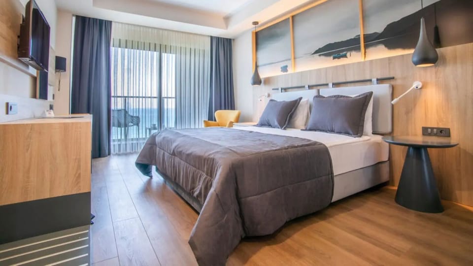 Deluxe Suite, Sea View | Premium bedding, minibar, in-room safe, individually decorated