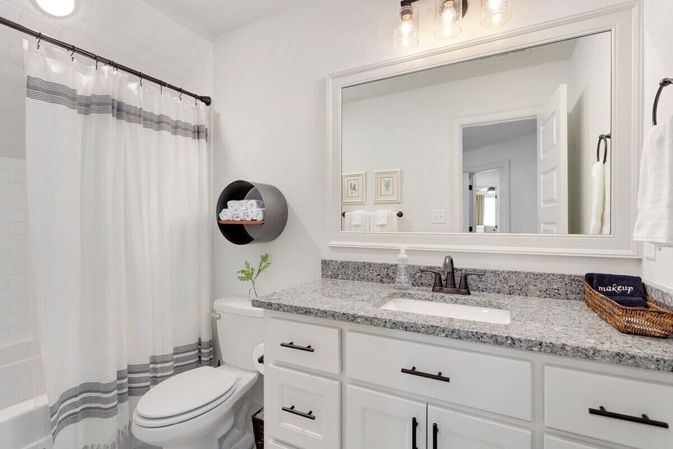 The Queen bedroom's en suite bath, featuring a shower with tub and luxury amenities.