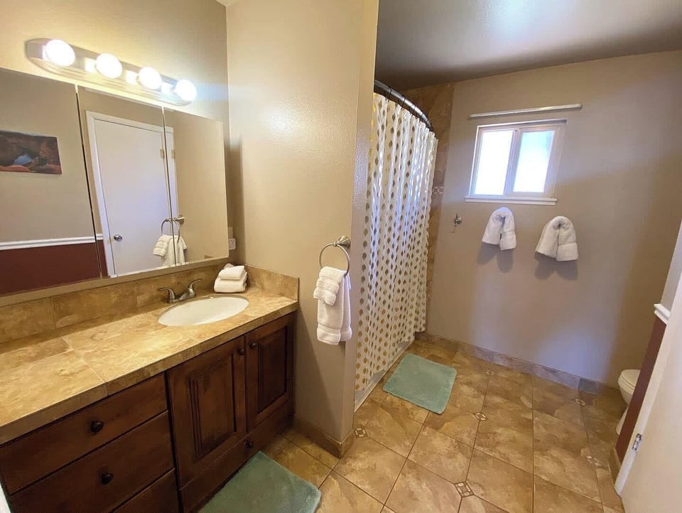 Refresh after your adventures in this spacious bathroom with a full tub and shower, fresh towels, and plenty of room to get ready.