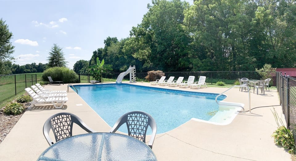 Pool with fence around it slide and diving board