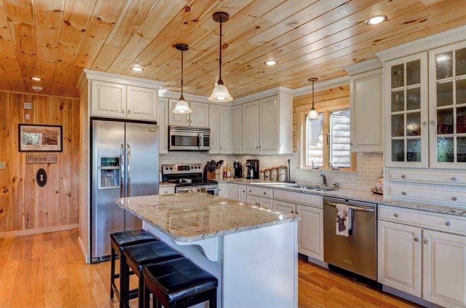 The beautiful kitchen with granite countertops, high-end stainless steel appliances, and a cozy breakfast bar that seats 3.