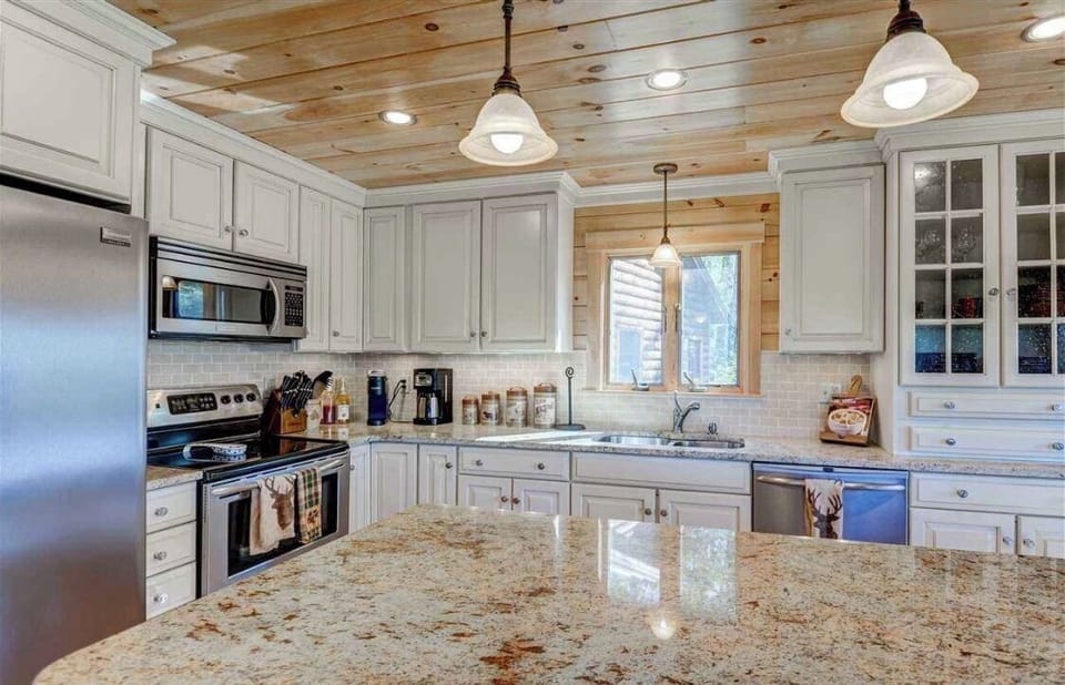 Warm, bright and fully stocked for all your cooking needs, the kitchen features granite countertop and a Keurig coffee maker.