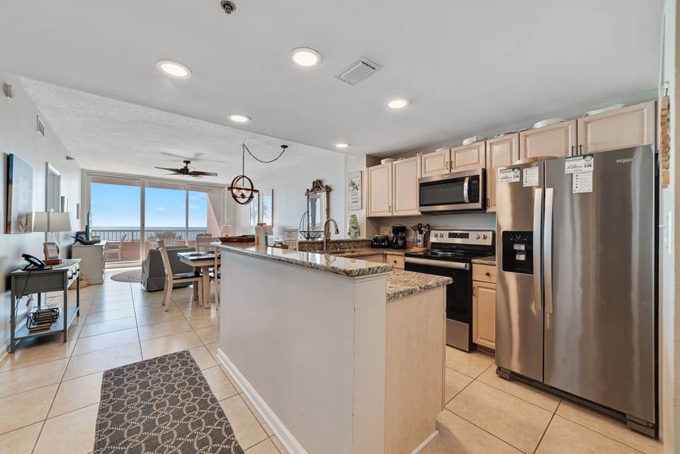 Updated kitchen with stainless steel appliances, quartz countertops, and a contemporary backsplash, offering both functionality and aesthetic appeal.