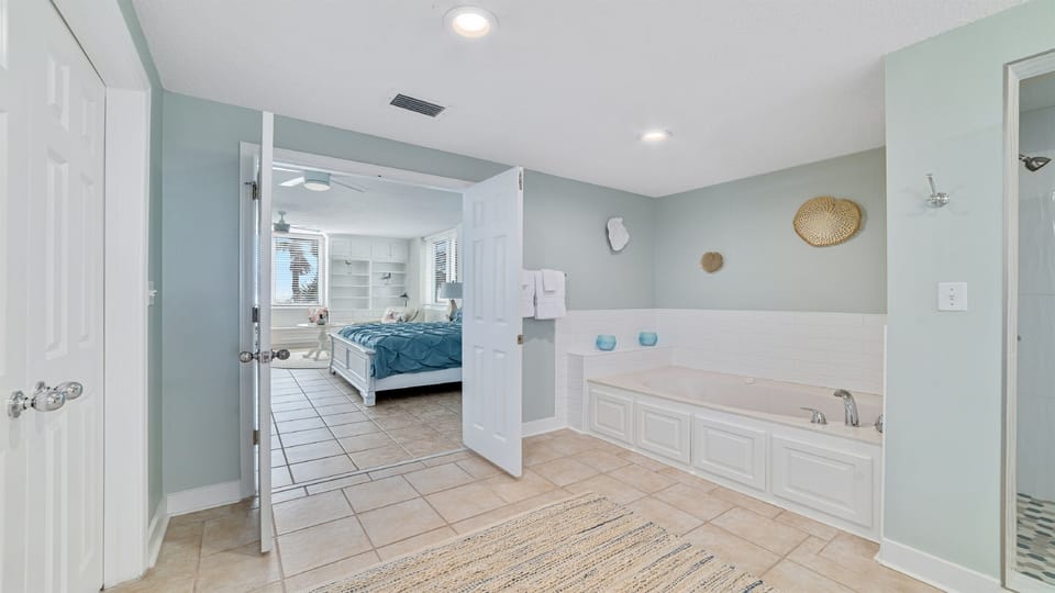 Discover this luxurious ensuite bathroom featuring a deep soaking tub, ample storage, and direct access to the primary bedroom.