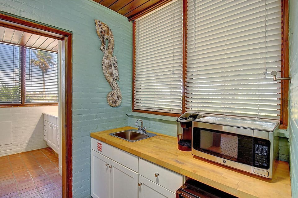 Your bright kitchenette features warm wood countertops and coastal charm, perfect for preparing morning coffee or light meals.