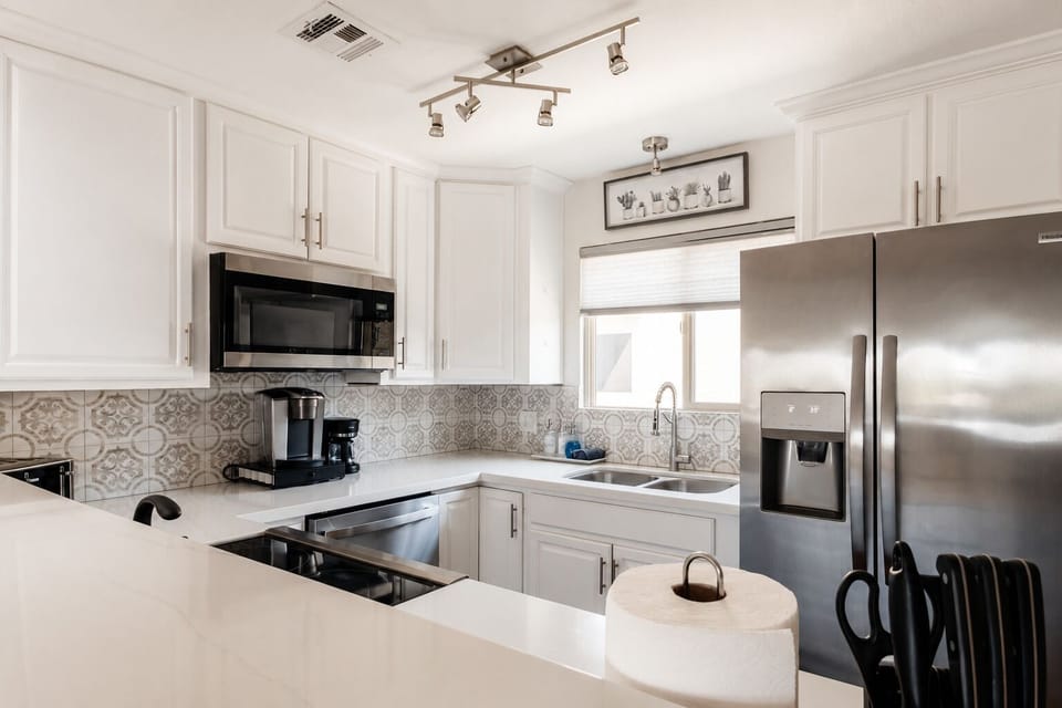 Bright, fully equipped kitchen with Keurig, drip coffee maker & modern appliance