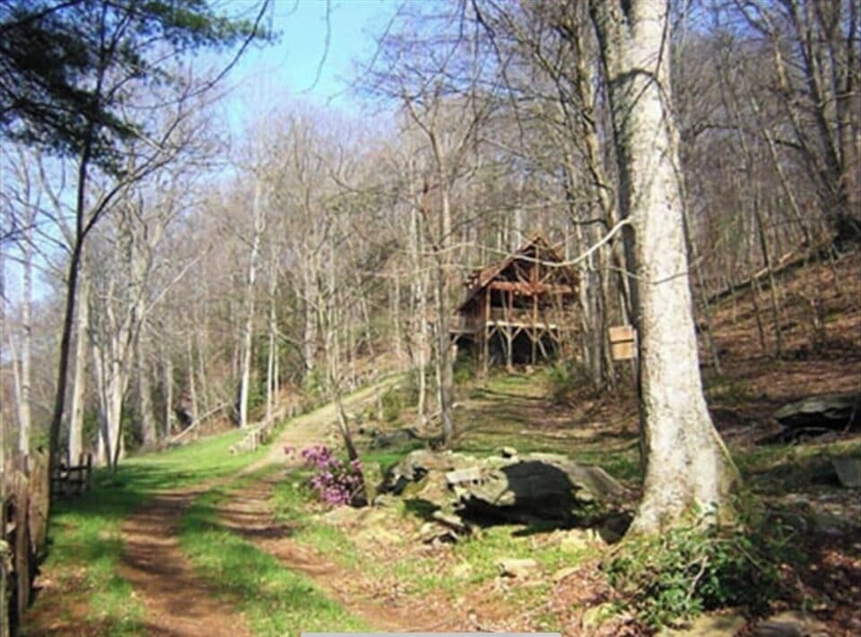 Road and hill that goes up behind the cabin to main door and parking space.  