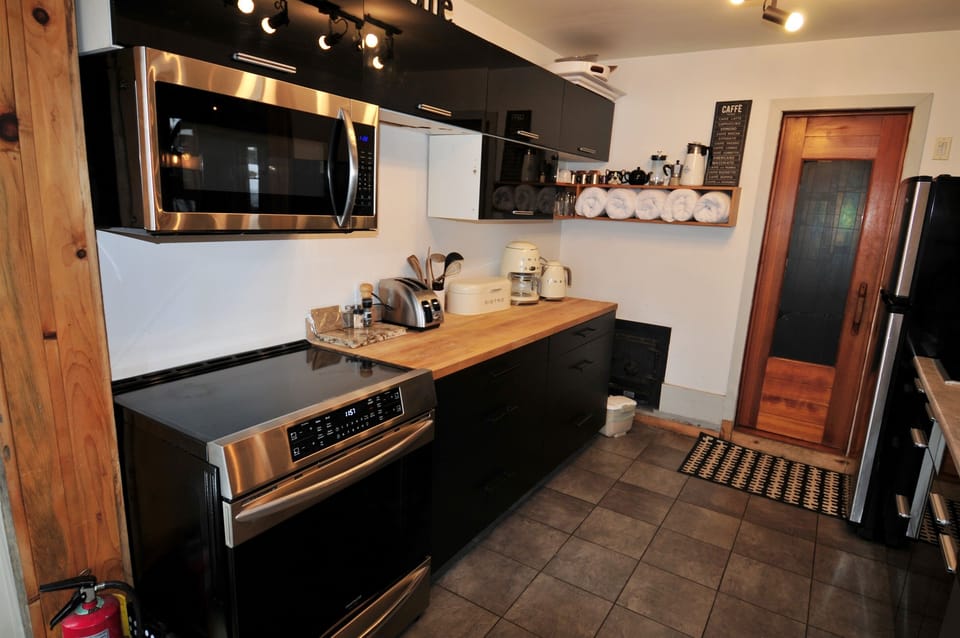 Kitchen layout with induction stove with door to interior sauna in back