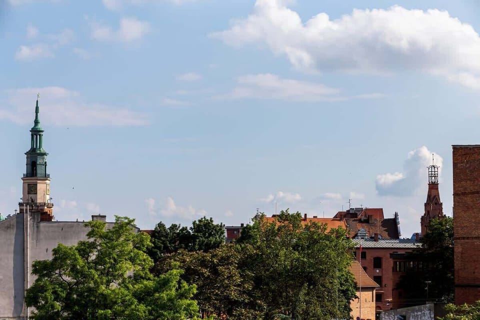 A scenic view of a city skyline with historic buildings and greenery from a balcony.
