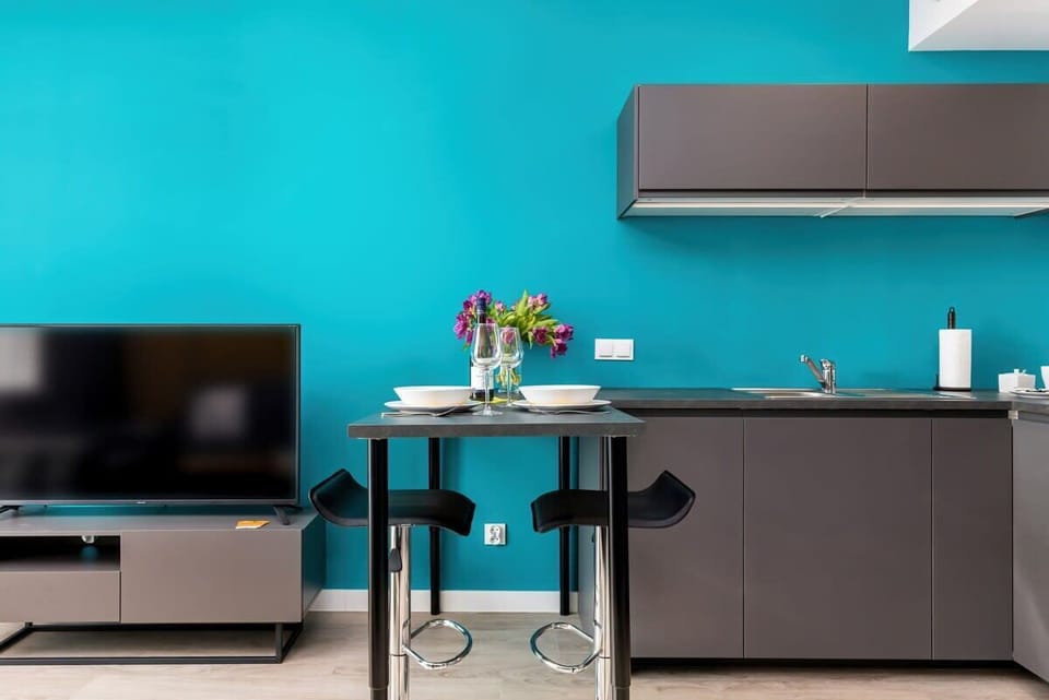 A modern kitchen with a black-and-gray color scheme. Bar stools are set along a counter for casual dining.