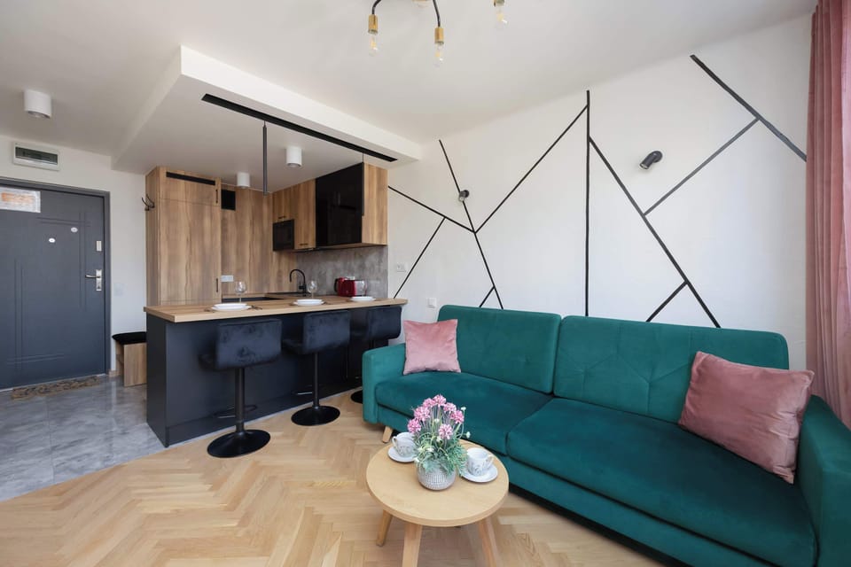 Living room with sofa and open kitchen in the background.