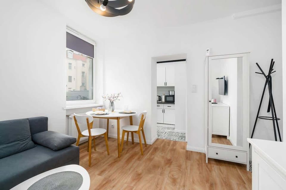 A dining area in an open-plan layout, with a table and chairs positioned near a sofa for a functional living-dining combo.