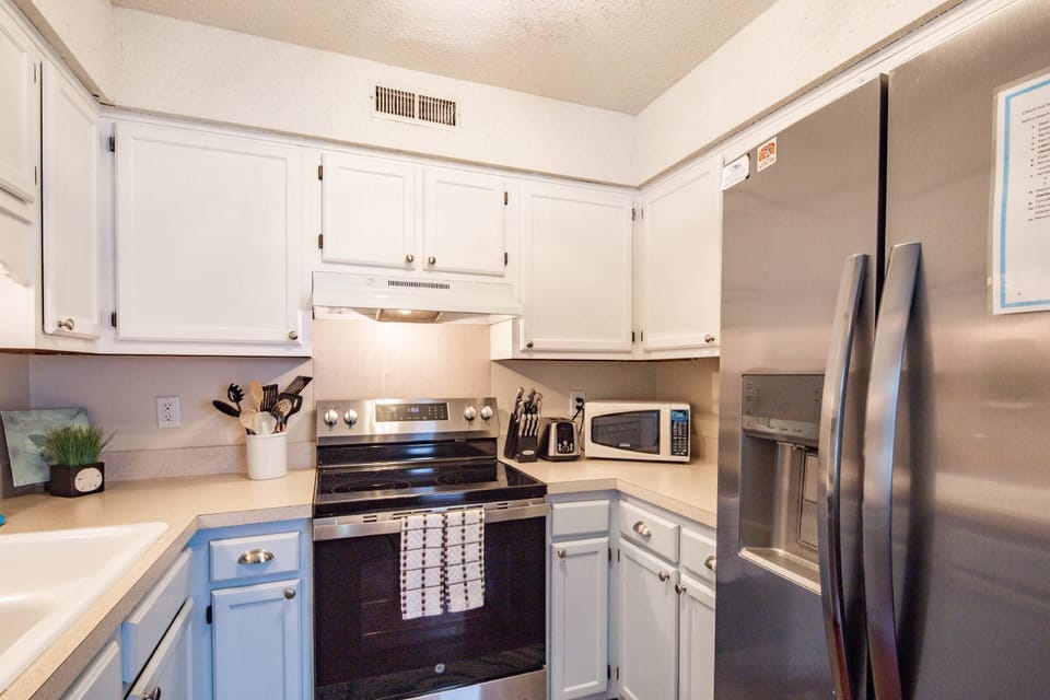 The kitchen features a range, microwave, toaster and refrigerator.