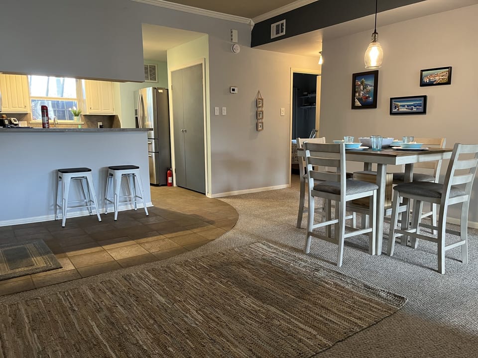 Open concept kitchen with additional stools at bar and dining area
