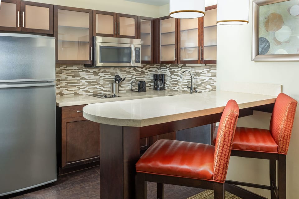 Kitchen area with full cabinetry, refrigerator, and appliances.