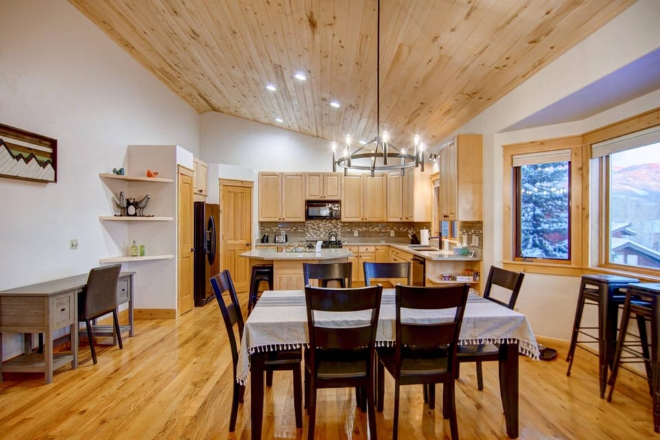 Bright and spacious kitchen and dining area with vaulted wood ceilings, mountain views, and room for everyone.