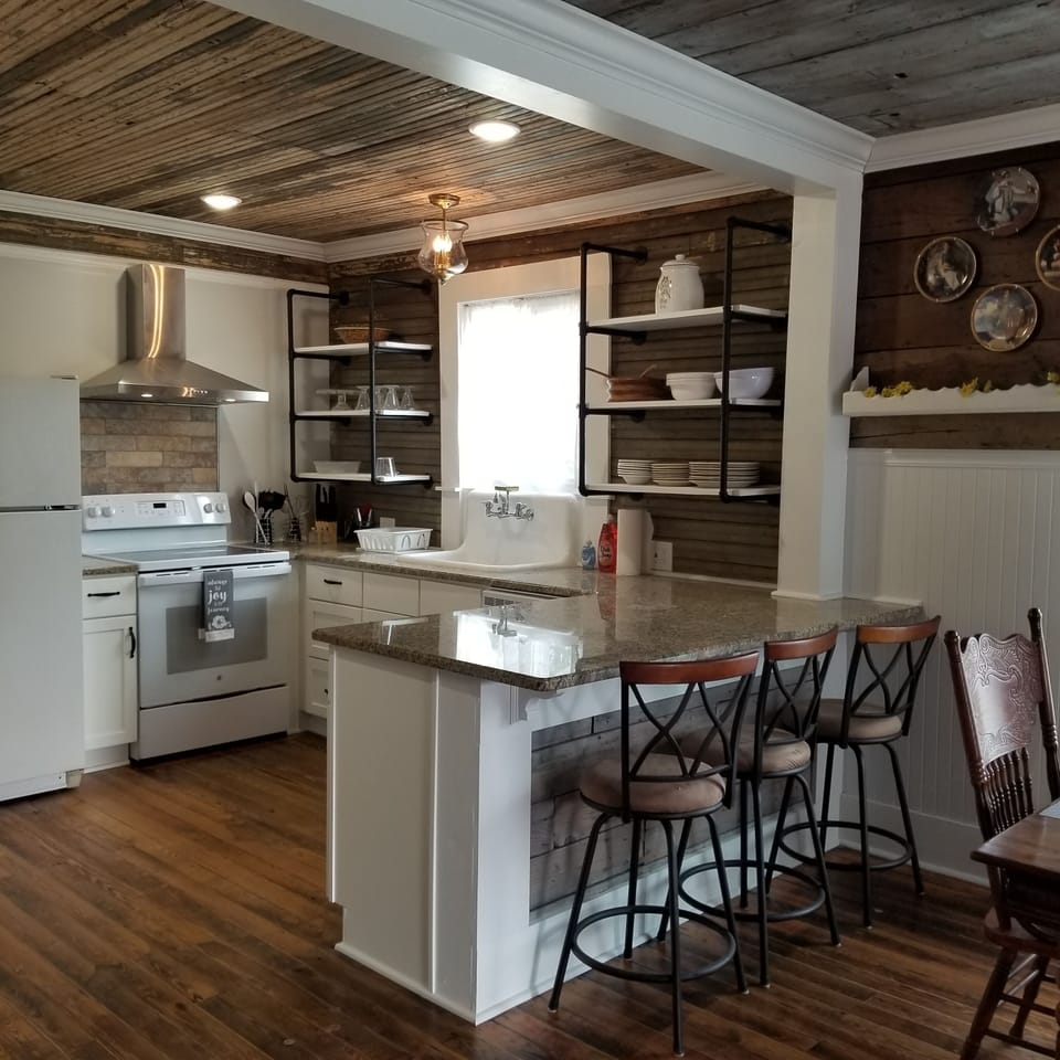 Kitchen has fridge with icemaker, dishwasher, glass top stove, island. 