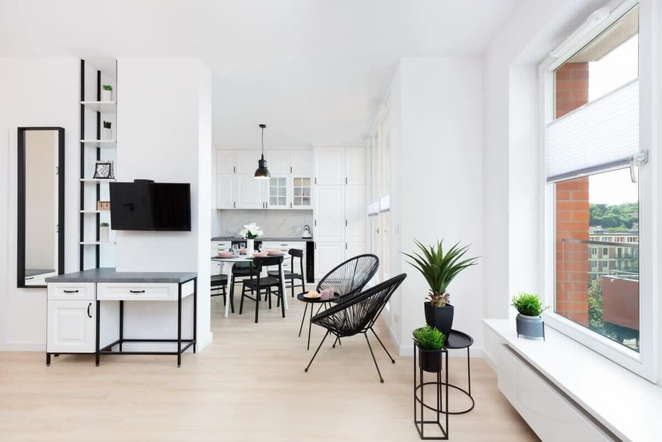 Another view of the living room featuring a sleek TV unit, a blue sofa, and tasteful decor.
