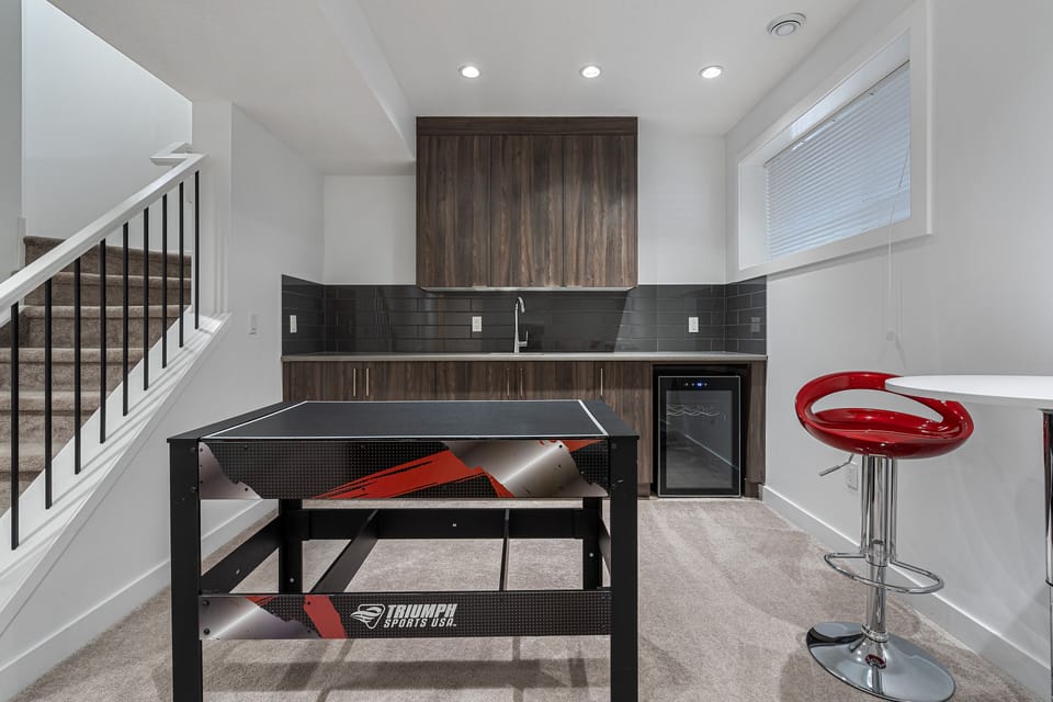 clean bright and spacious game room in basement with fridge
