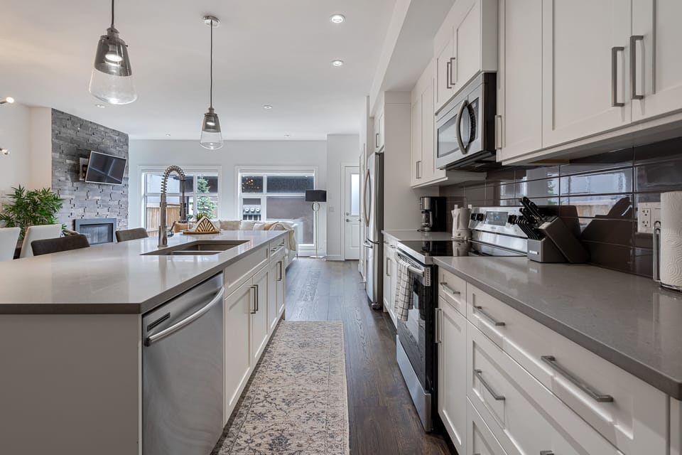 modern kitchen with stainless appliances, coffee and tea facilities, utensils,