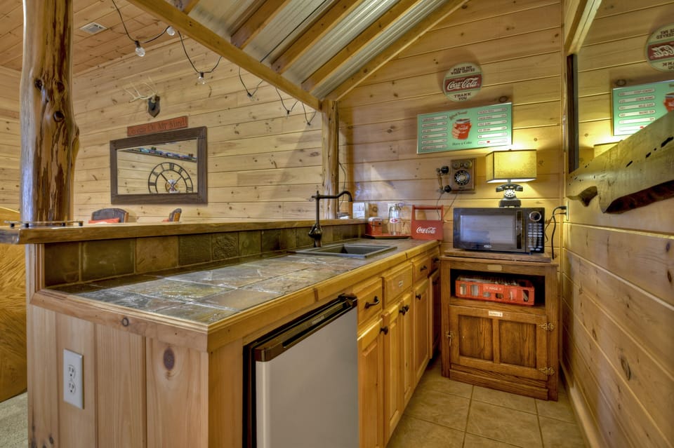 Wet bar area in rec room with minifridge and microwave 