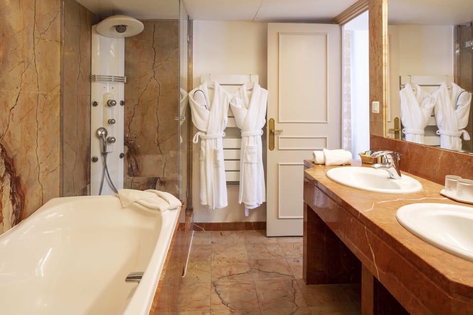 Bathtub, designer toiletries, hair dryer, bathrobes