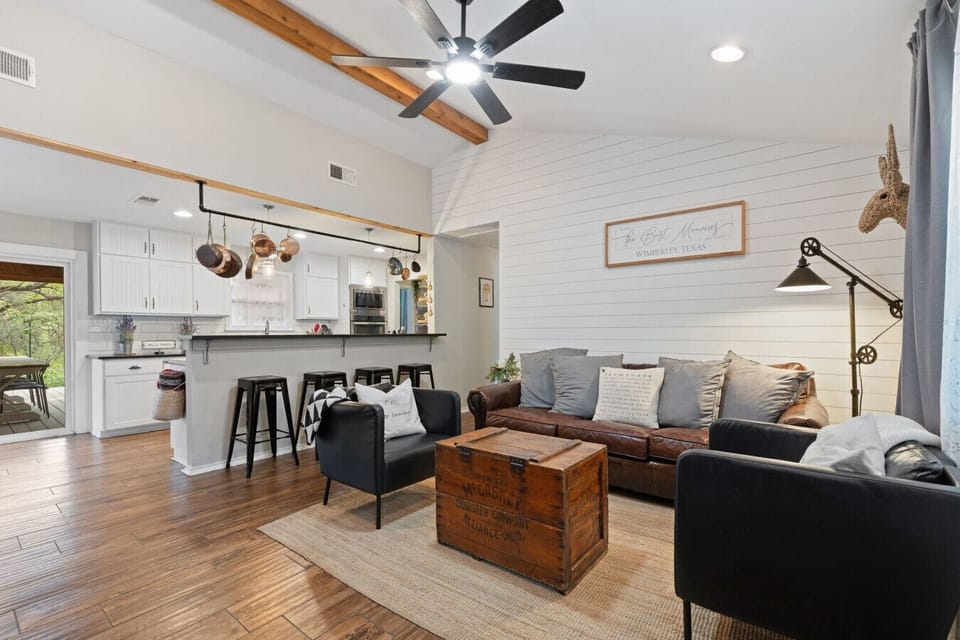 The Lazy Lavender Farmhouse in Wimberley Texas — Living Room with Exposed Beams, Restoration Hardware Sofa and Kitchen Bar