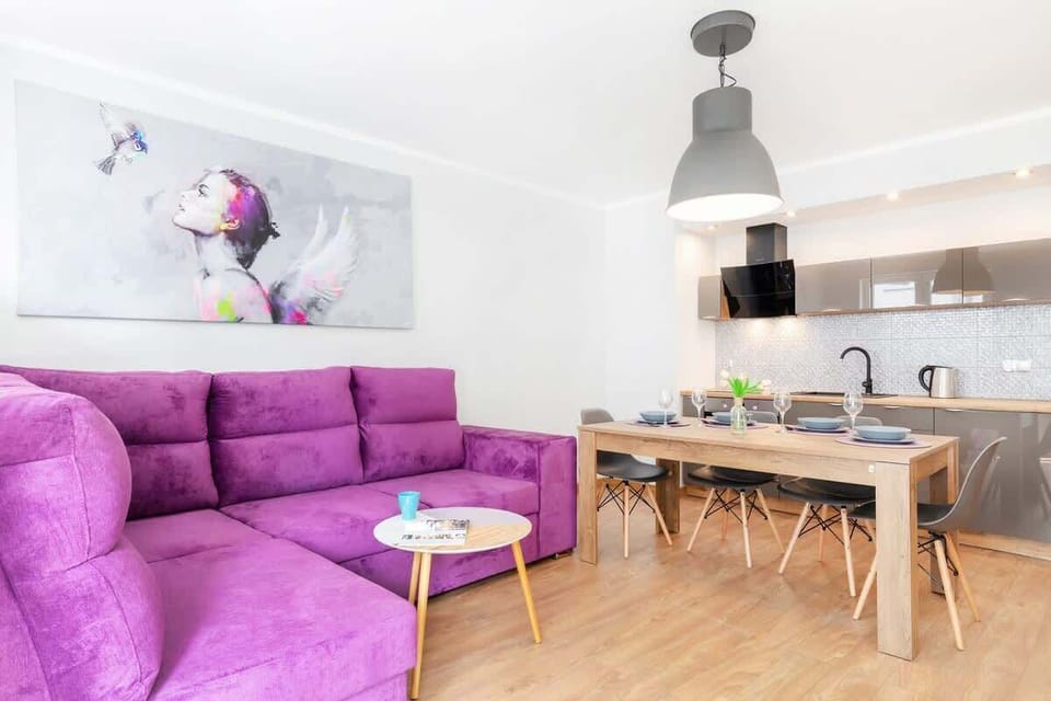 Living room with a fold-out sofa bed, dining area and kitchenette.