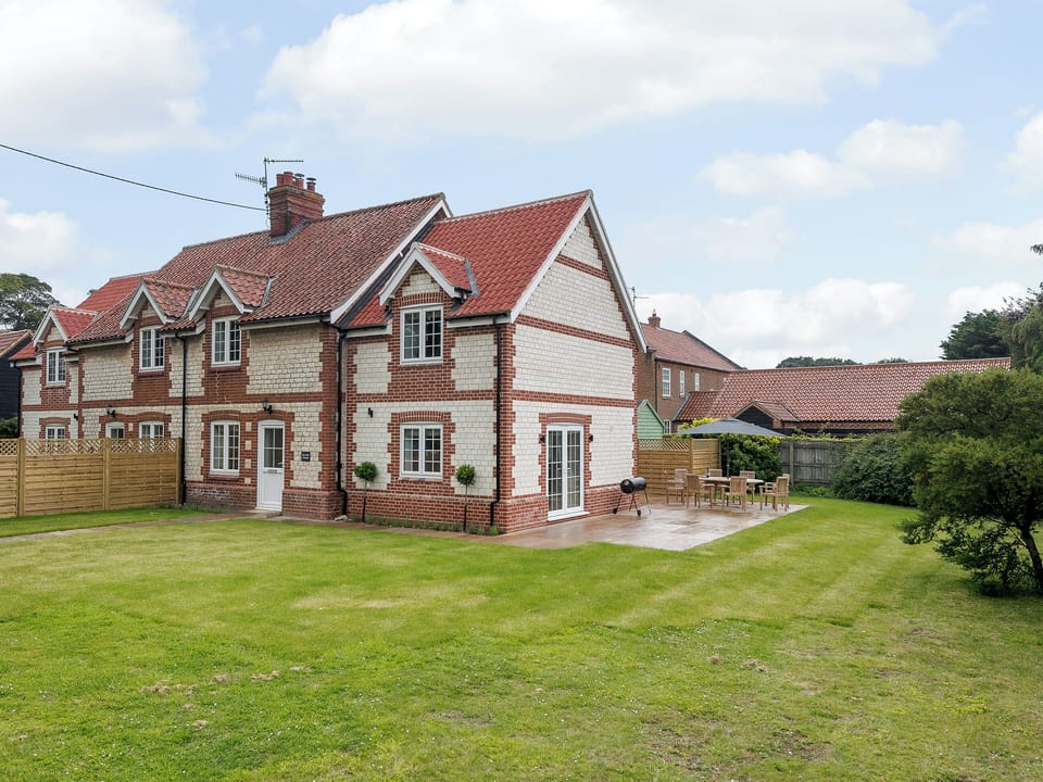 Enclosed lawned courtyard with sun deck, garden furniture and BBQ | Sea Holly Cottage - Hall Lane Cottages, Thornham, near Kings Lynn