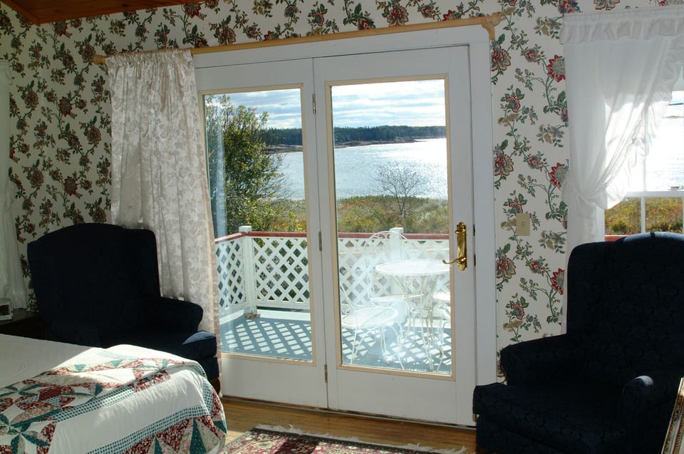 Bedroom 1 with cathedral ceiling and French doors open on to deck, en suite bath
