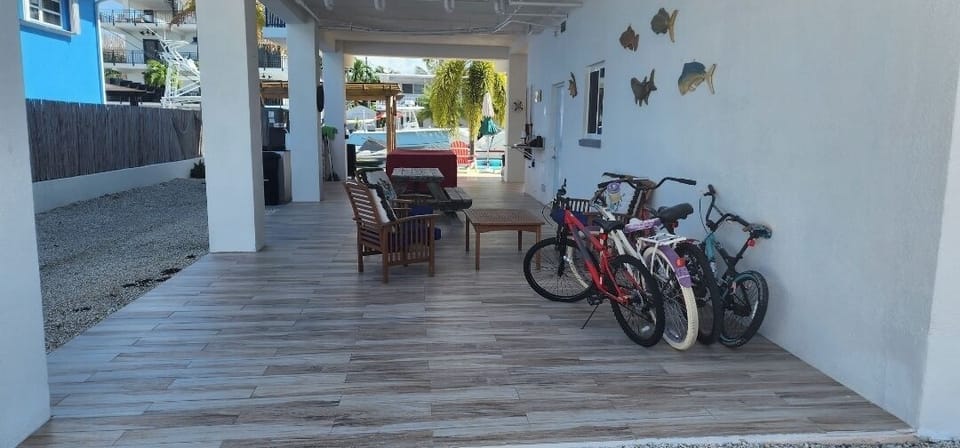 view when enter property, shaded area with pool and dinning table.