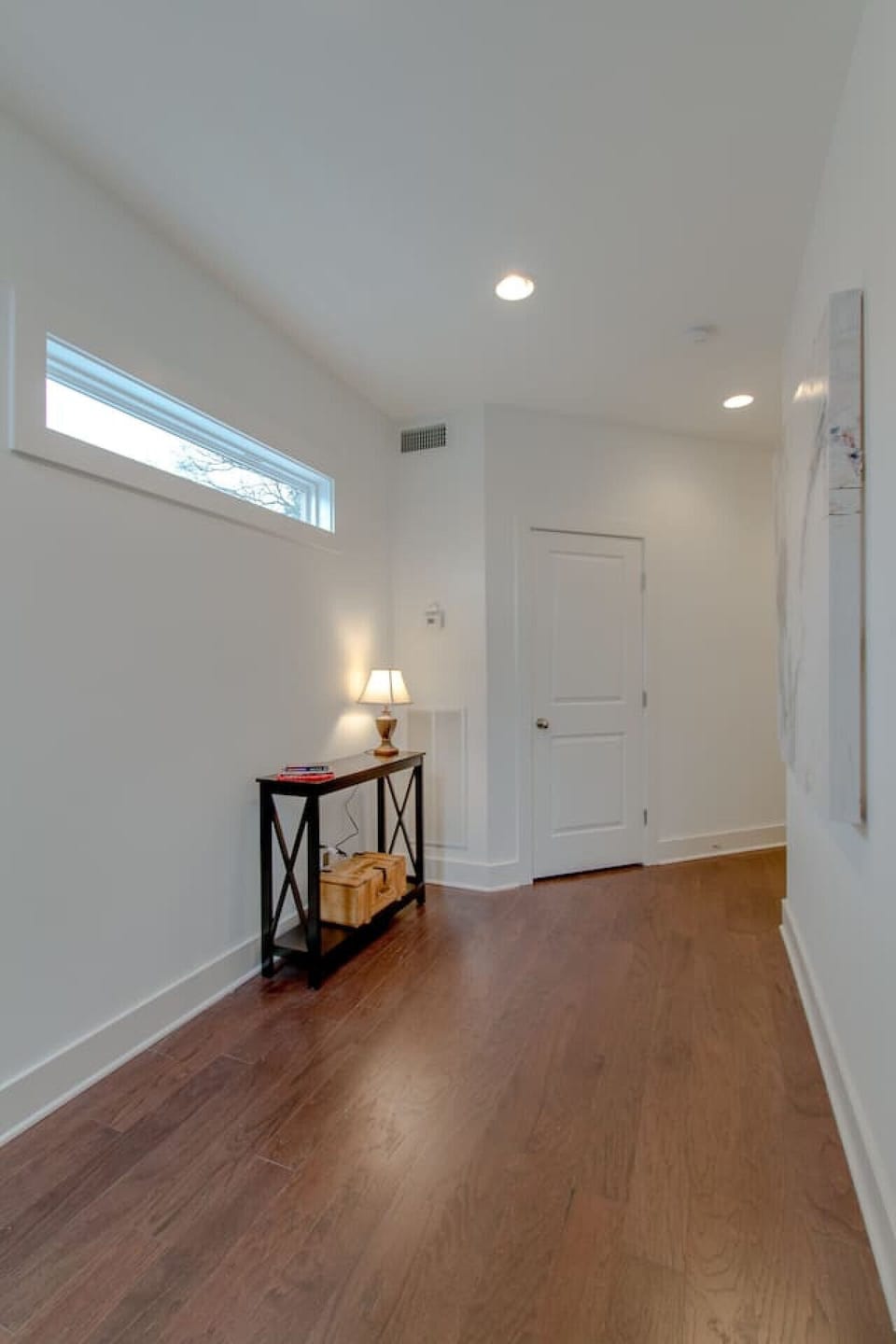 Second-floor landing with skylight, console table, and table lamp