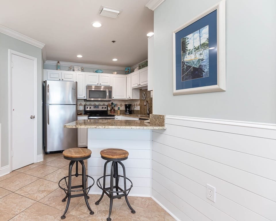 Gather around the stylish breakfast bar with two stools, perfect for casual meals in the inviting kitchen space
