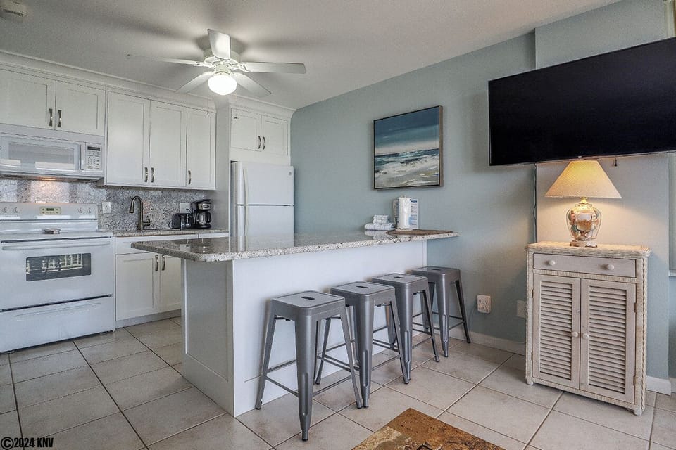Four stools and a large granite countertop offer guests a comfortable way to dine