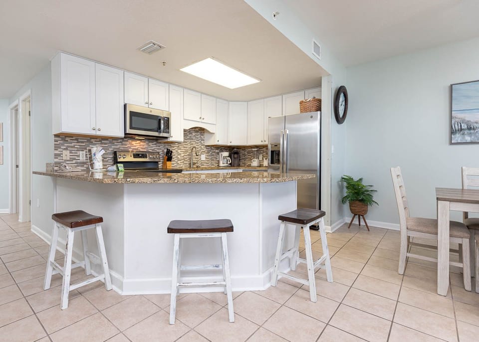 Gather around the kitchen bar with seating, perfect for casual meals and conversations in a welcoming atmosphere