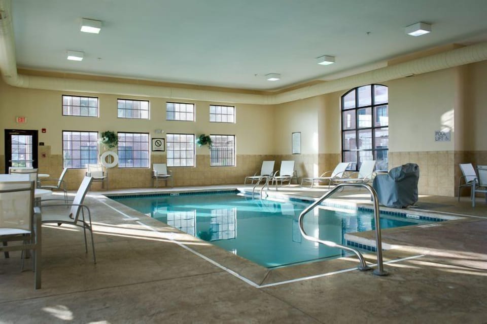 Heated indoor pool with blue tile surround — open daily 7:00 AM to 11:00 PM for guests