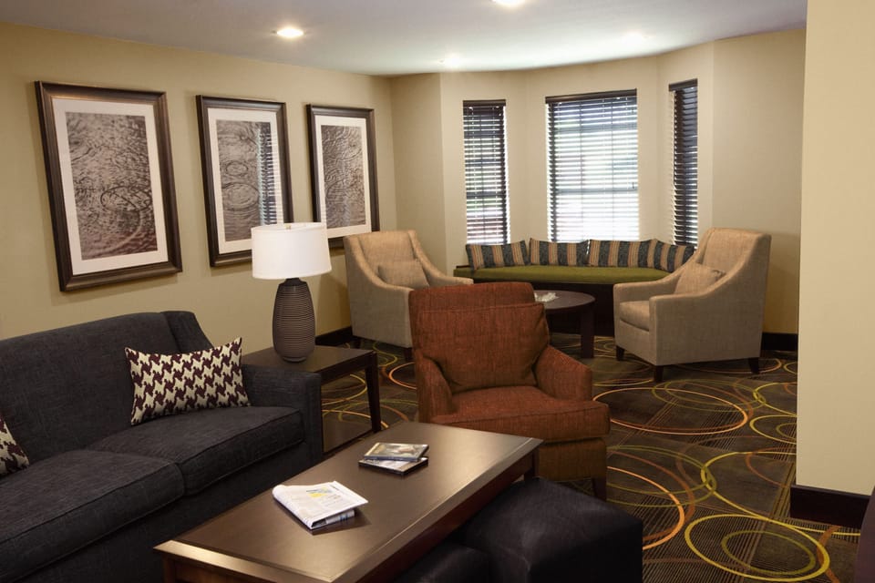 Sitting area with cushioned seating, artwork, and natural light.