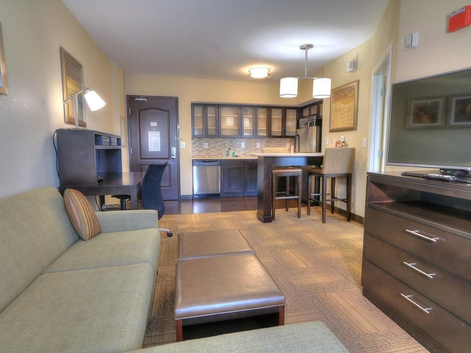Work desk positioned beside large windows — natural light and WiFi included for productive stays