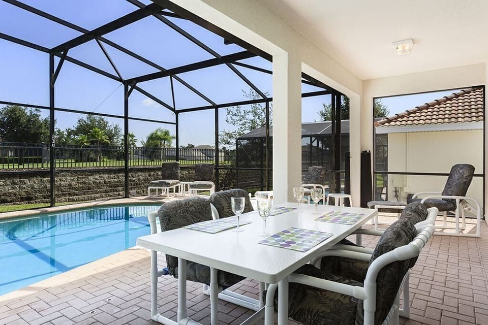 View 2 of luxurious patio furniture with pool, spa, and sliding glass door to access the villa