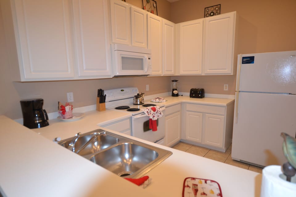 Fully equipped kitchen with cooking utensils and full sized refrigerator 