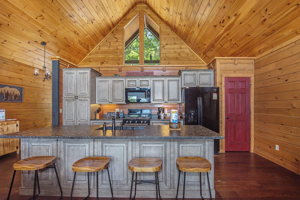 Cook your favorite meals in this rustic kitchen with granite counters, full appliances, and charming wooden bar seating for easy entertaining.