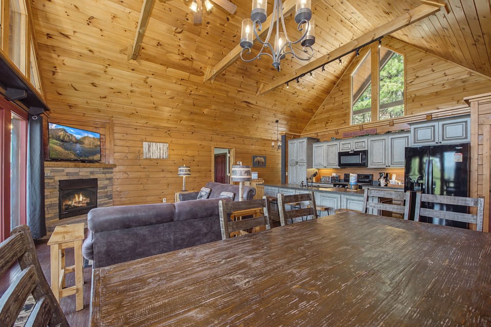 Gather around this expansive dining table where your group can share meals while enjoying the warmth of the fireplace and mountain views.