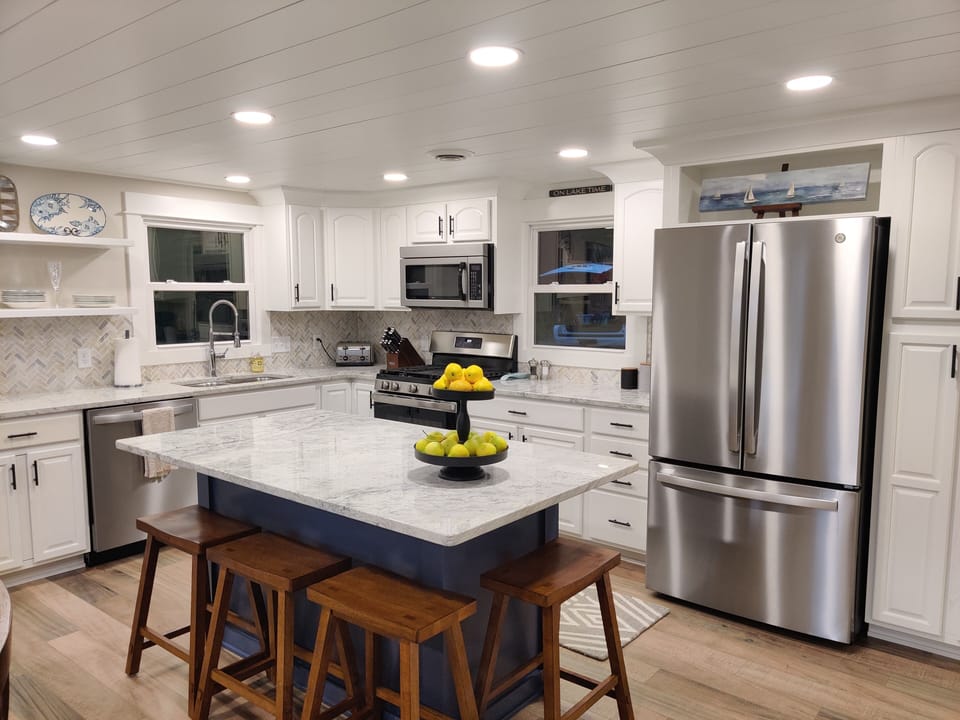 Spacious kitchen with a large island, stainless steel appliances and dishwasher.