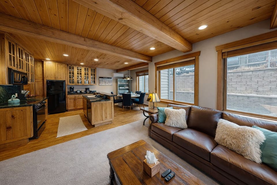 Sink into your plush sectional sofa while the fireplace crackles and natural light streams through wooden blinds in this cozy mountain retreat.