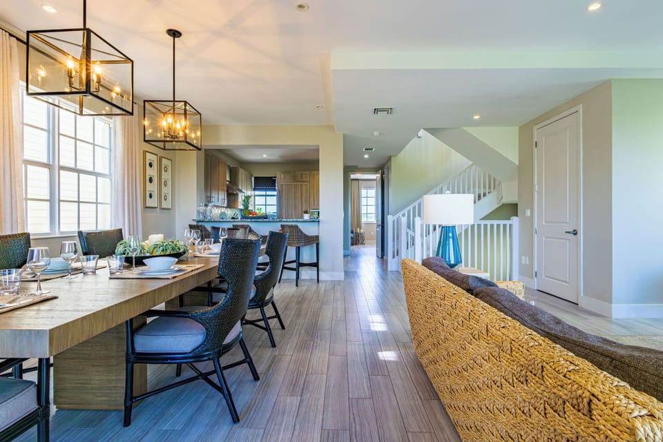 Spacious open-plan dining area flowing into a modern kitchen and living space.