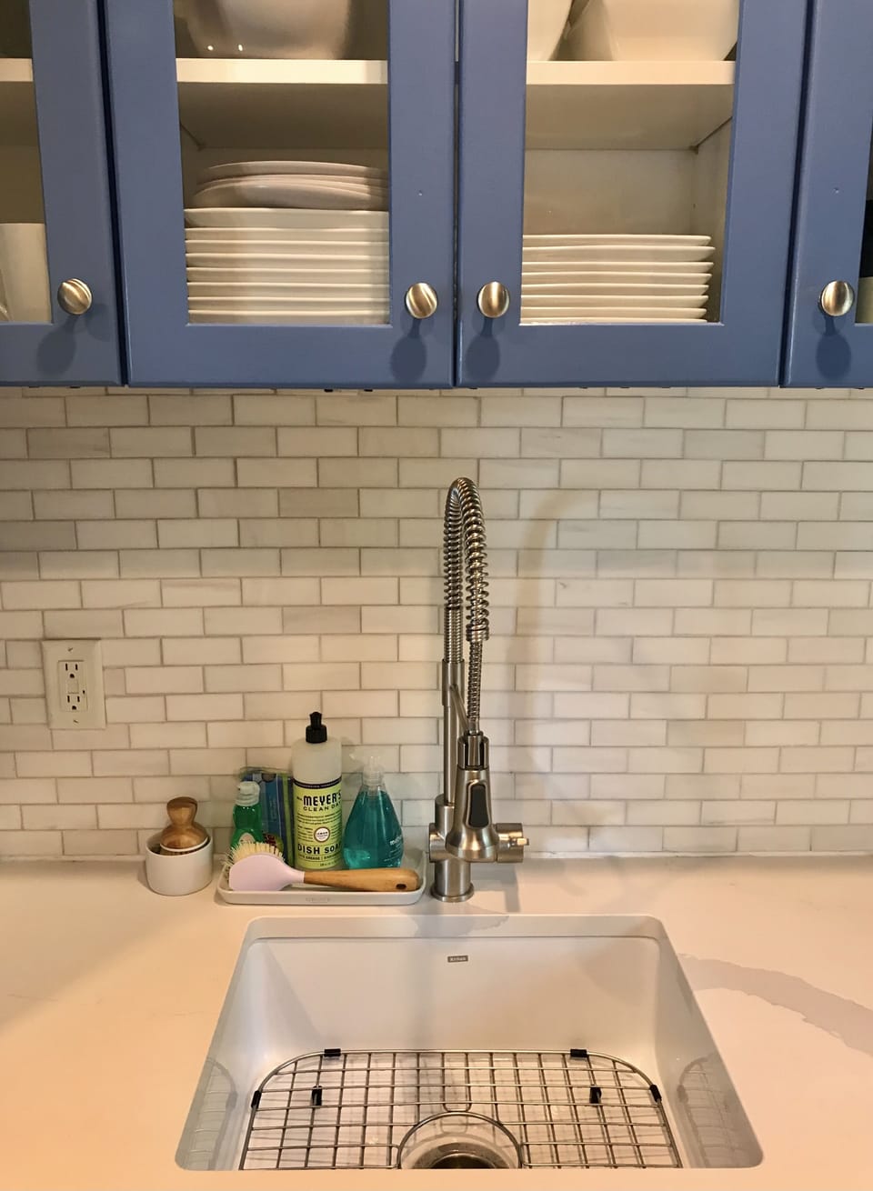 New quartz countertops, marble backsplash, dishware, and appliances.