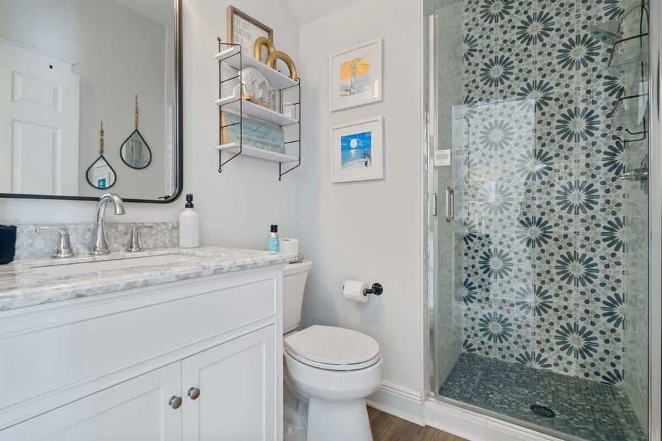 - Bright & fresh with a white vanity, granite counters, & wall art that feels like the beach - Step into the walk in shower with patterned tile for a quick rinse or relaxing escape - Wall shelves add charm & offer storage for your getaway essentials