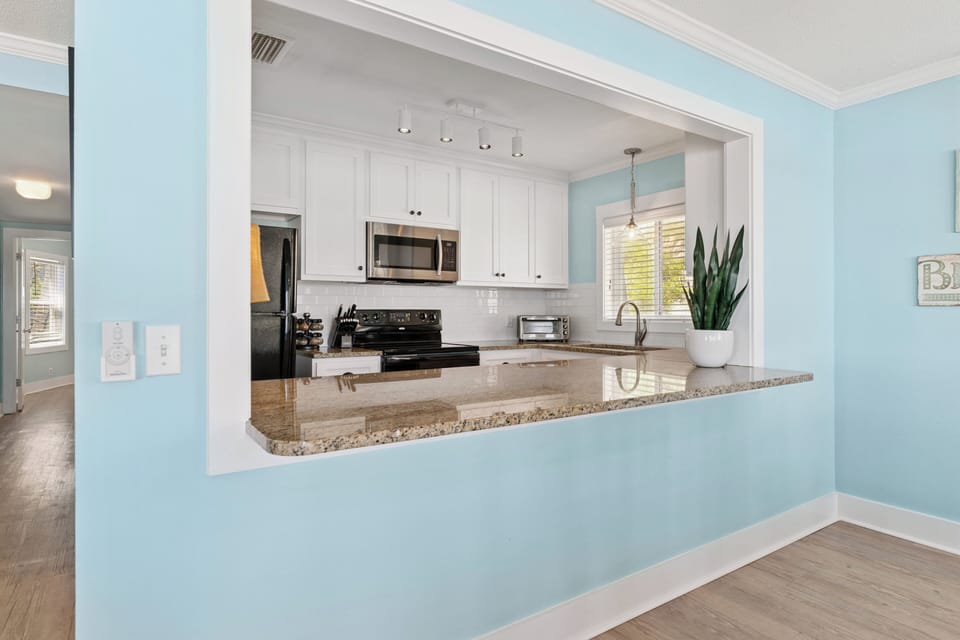 Prepare your favorite meals in this bright, open kitchen featuring granite countertops, modern appliances, and a convenient breakfast bar perfect for morning coffee.